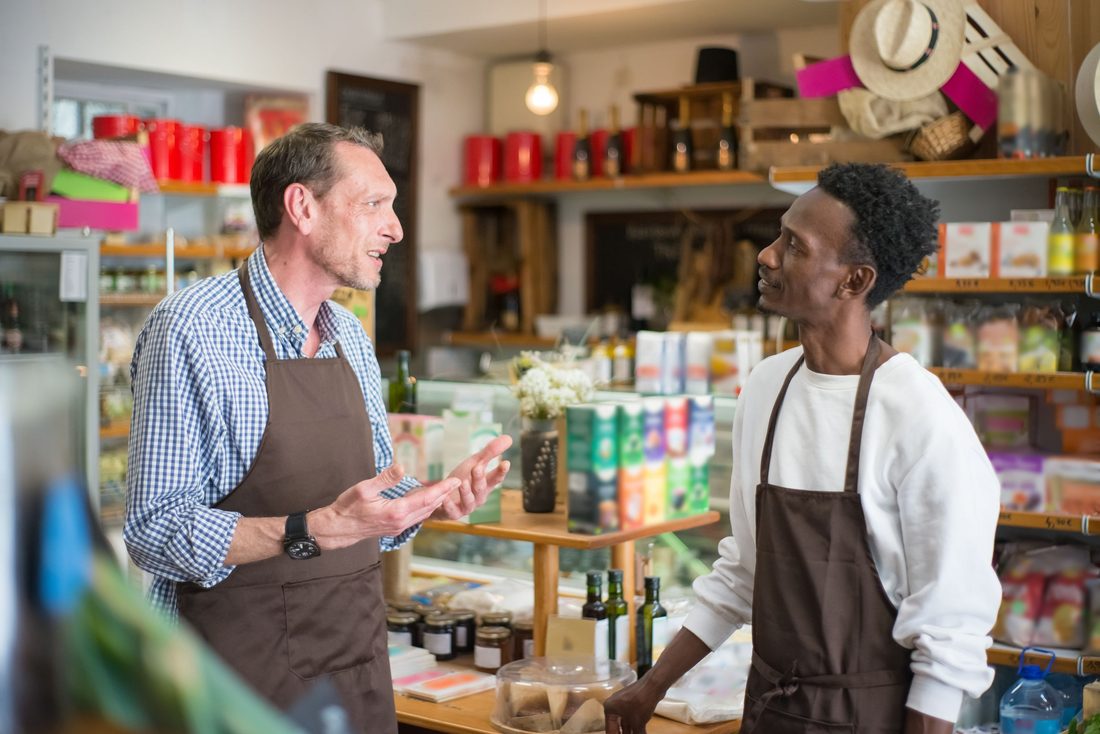Équipe d'un commerce alimentaire au comptoir, gérant et collaboratrice